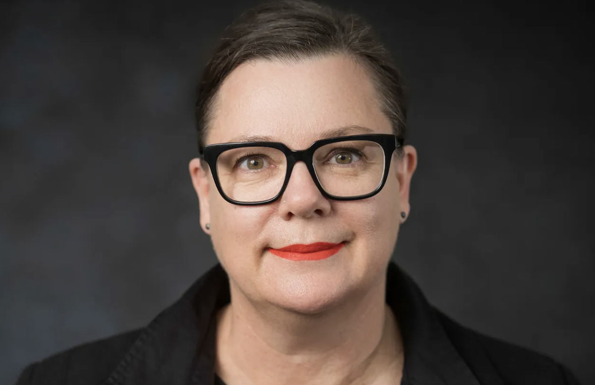 Arts South Australia CEO Christine Schloithe wearing black-rimmed glasses and red lipstick posing for an official professional headshot portrait.